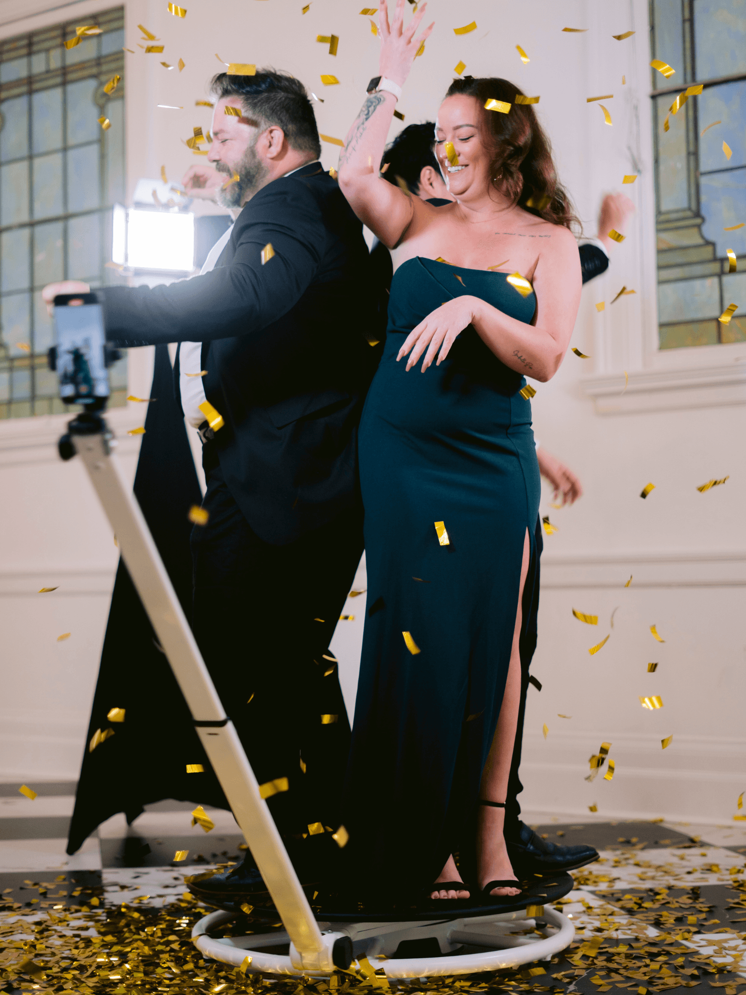 Couple on the 360 booth with gold confetti falling in an elegant venue