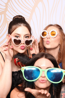 Wedding guests laughing while wearing oversized novelty glasses