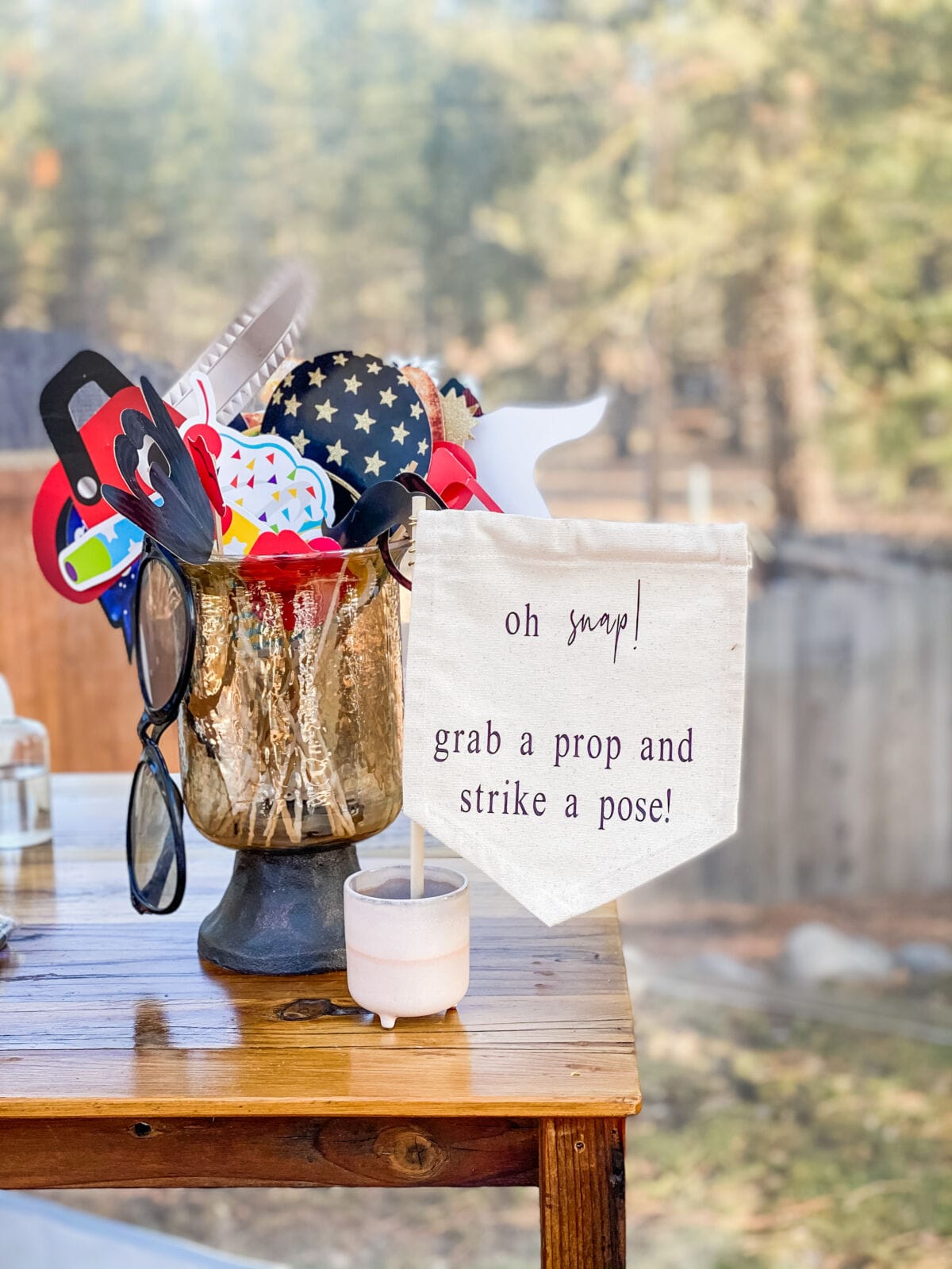 A bucket of photo booth props beside an "oh snap, grab a prop and strike a pose" banner