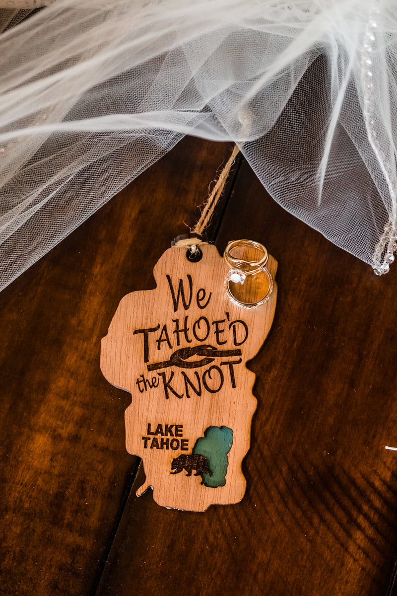 A "We Tahoe'd the Knot" wooden Lake Tahoe sign with wedding rings and a veil