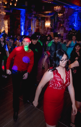 Guests dancing under colored event lighting on the dance floor